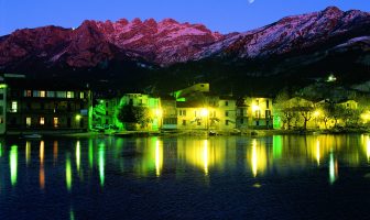 rione Pescarenico di sera illuminato con sullo sfondo il Monte Resegone