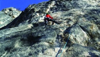Persona che arrampica sulla parete rocciosa lungo la Falesia di Versasio