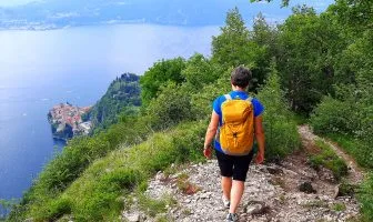 Persona che percorre il Sentiero del Viandante  con panorama su Varenna