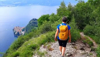 Persona che percorre il Sentiero del Viandante  con panorama su Varenna