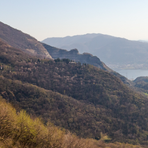 Persona che arrampica in falesia sopra Lecco con panorama